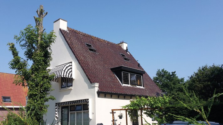 Gepleisterde crème gevel met zwart houtwerk in Roosendaal.