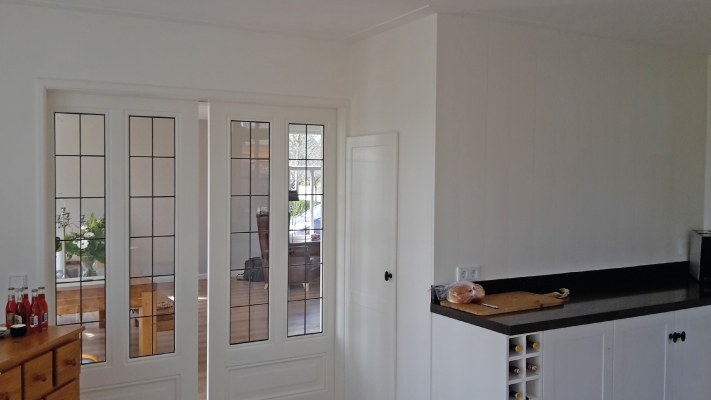 Witte schuifdeuren met glas.